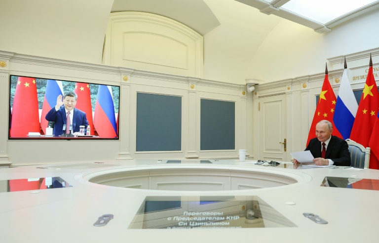 Photo diffusée par l'agence de presse russe Sputnik montrant le président russe Vladimir Poutine (d) s'entretenant par visioconférence avec le président chinois Xi Jinping, le 4 février 2026 à Moscou