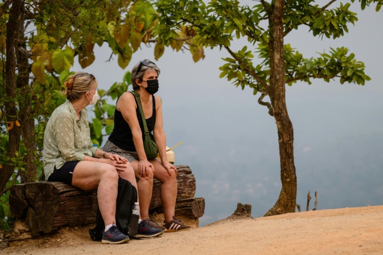 Des touristes portent un masque pour visiter le canyon de Pai, dans le nord de la Thaïlande, le 1er avril 2026