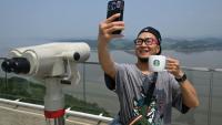 Un touriste prend un selfie avec une tasse Starbucks devant la Corée du Nord depuis une plate-forme d'observation sud-coréenne située à l'Écoparc de la Paix d'Aegibong, à Gimpo, le 1er juillet 2026 
