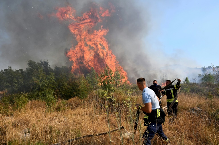 Les pompiers tentent d'éteindre un incendie de forêt dans la banlieue de la capitale du Monténégro, Podgorica, le 11 août 2025, alors que les températures ont atteint 40°C
