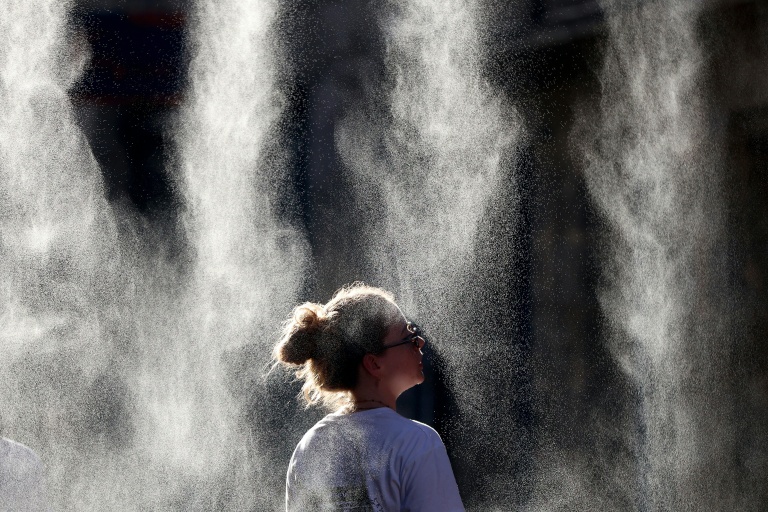Une femme se rafraîchit sous un brumisateur lors de la Fête de la Musique à Bordeaux, le 21 juin 2026  