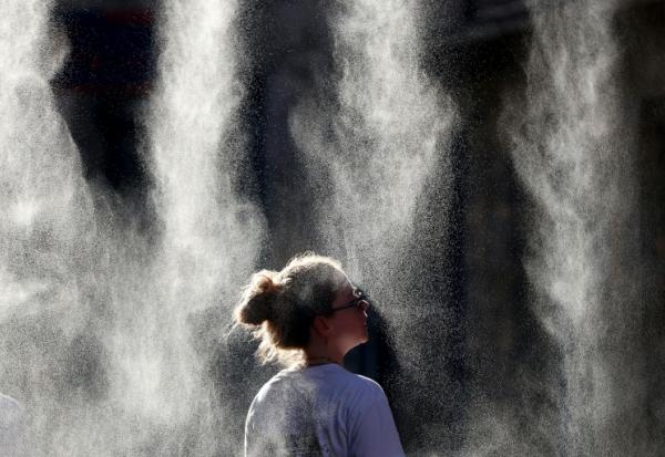 Une femme se rafraîchit sous un brumisateur lors de la Fête de la Musique à Bordeaux, le 21 juin 2026  