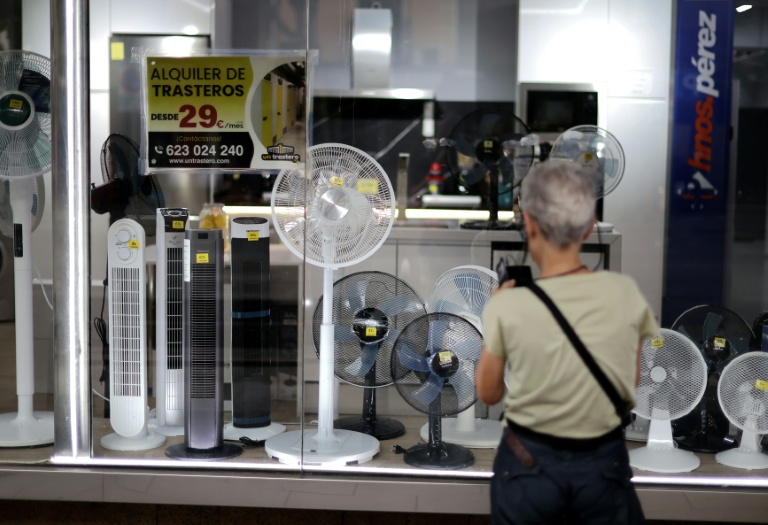 Une femme devant un magasin vendant des ventilateurs à Madrid le 25 juin 2026