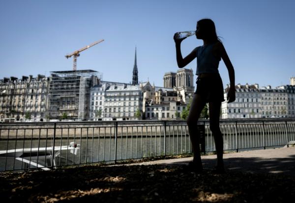 Une jeune femme s'hydrate pendant la canicule, le 24 juin 2026 à Paris