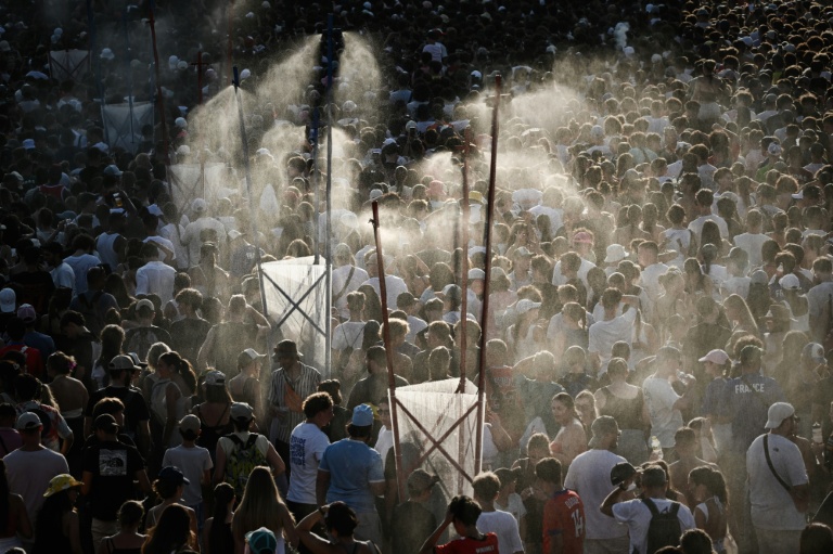 Des festivaliers se rafraichissent sous des jets d'eau mis en place pour lutter contre la canicule le 11 juillet 2026 au festival des Francofolies de La Rochelle en Charente-Maritime