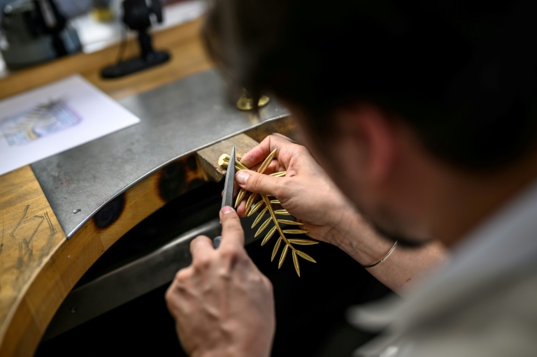 Un artisan lors d'une démonstration sur la fabrication de la Palme d'or de Cannes, le 21 avril 2026, dans un atelier de la maison Chopard à Meyrin, près de Genève 