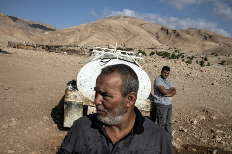 Un bédouin palestinien et son fils à proximité d'une citerne à Ras Ein al-Auja, dans la vallée du Jourdain, en Cisjordanie occupée, le 30 septembre 2025 
