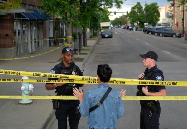 Des policiers parlent avec un passant sur les lieux d'une attaque contre des manifestants pour la libération d'otages israéliens retenus à Gaza, sur Pearl Street à Boulder, Colorado, le 1er juin 2025