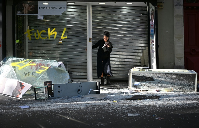 Une commerçante devant sa boutique endommagée au lendemain d'une manifestation contre le vie chère, le 18 octobre 2026 à Paris