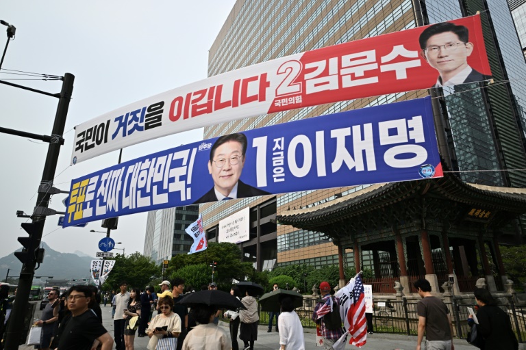 Des banderoles des candidats à la présidentielle Kim Moon-soo (en rouge) et Lee Jae-myung dans une rue de Séoul, le 31 mai 2025, avant l'élection du 3 juin