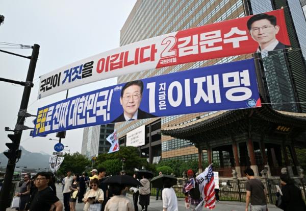 Des banderoles des candidats à la présidentielle Kim Moon-soo (en rouge) et Lee Jae-myung dans une rue de Séoul, le 31 mai 2025, avant l'élection du 3 juin