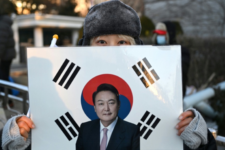 Une supportrice tient un portrait de l'ancien président sud-coréen destitué, Yoon Suk Yeol, devant le tribunal du district central de Séoul où doit se tenir son dernier procès pénal pour insurrection, le 13 janvier 2026