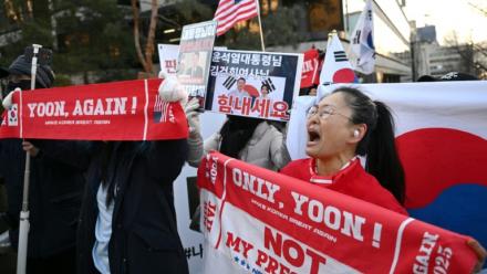 Des partisans de l'ancien président sud-coréen destitué, Yoon Suk Yeol, rassemblés devant le tribunal du district central de Séoul où doit se tenir son dernier procès pénal pour insurrection, le 13 janvier 2026
