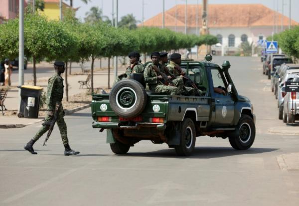 Des soldats armés patrouillent dans une rue près du palais présidentiel à Bissau, le 26 novembre 2025 en Guinée-Bissau