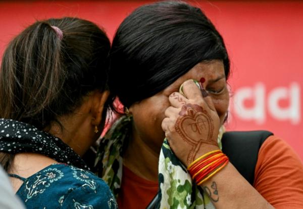 Des femmes pleurent la mort de leurs proches au lendemain du crash du vol Air India 171, à Ahmedabad le 13 juin 2025