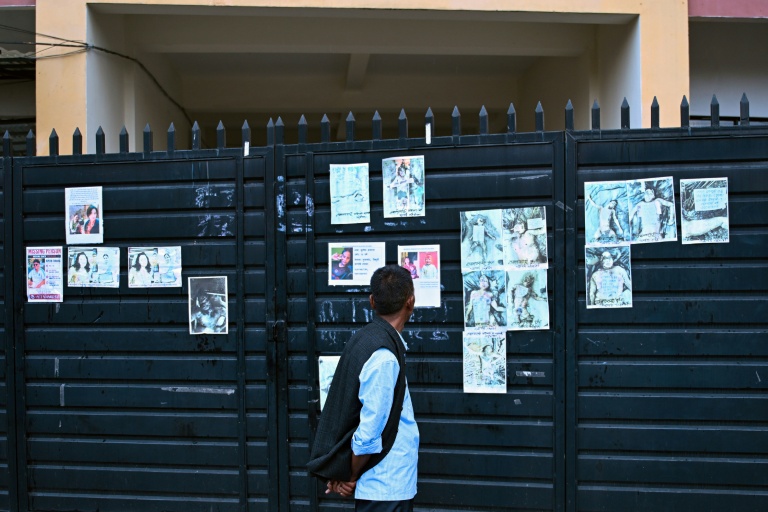 Un homme regarde les photos de personnes mortes ou portées disparues dans la crue destructrice qui a fait plus de 600 morts à la frontière entre le Népal et la Chine, le 29 août 2026 à Katmandou