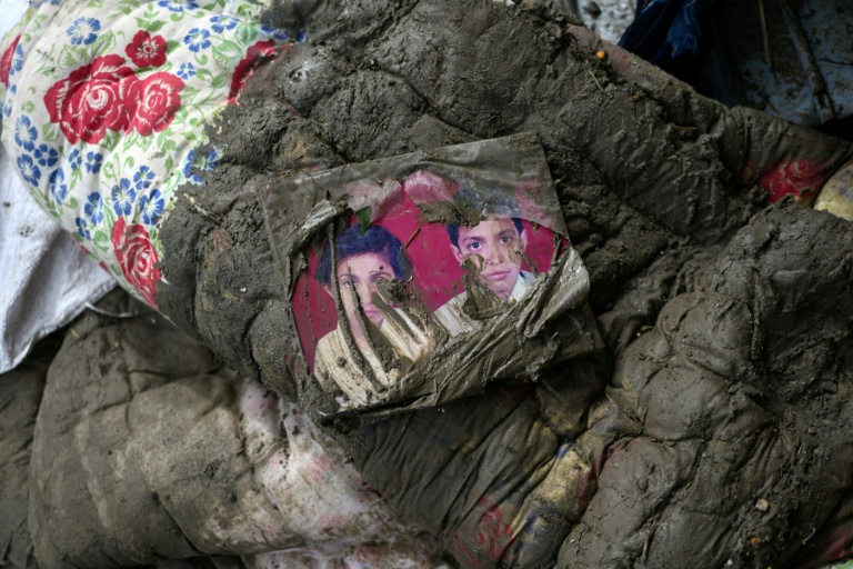 Une photo de famille souillée sur un matelas couvert de boue après la crue destructrice qui a fait plus de 600 morts à la frontière entre le Népal et la Chine, à Devighat, dans le district népalais de Nuwakot, le 29 août 2026