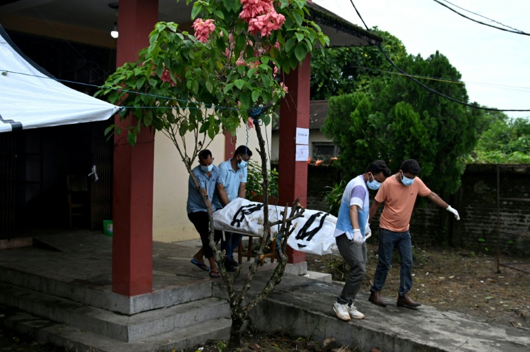Des soignants transportent le corps d'un mort après les crues  à l'extérieur d'une morgue dans le district de Chitwan, au Népal, le 31 août 2026