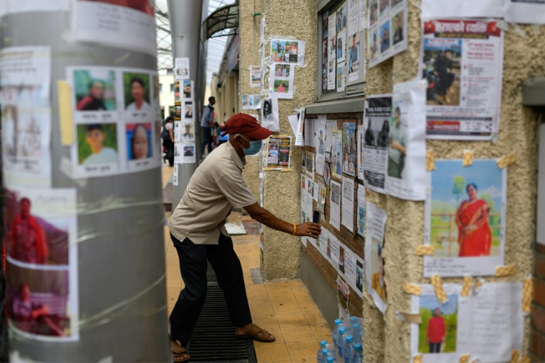 Un homme examine des photos de personnes disparues à la suite des crues à l'hôpital de l'université de Tribhuvan, à Katmandou, le 31 août 2026