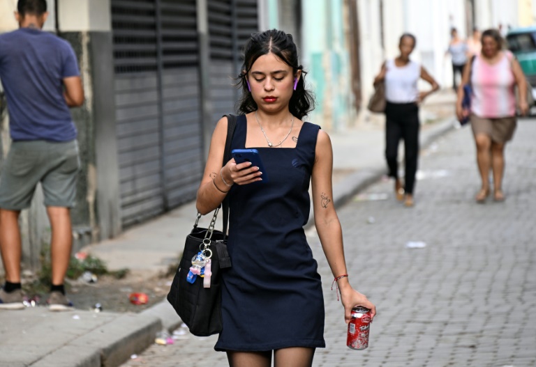 Une femme utilise son téléphone portable dans une rue de La Havane, le 3 juin 2025.
