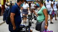 Des passants consultent un téléphone portable, à La Havane, le 14 juillet 2021