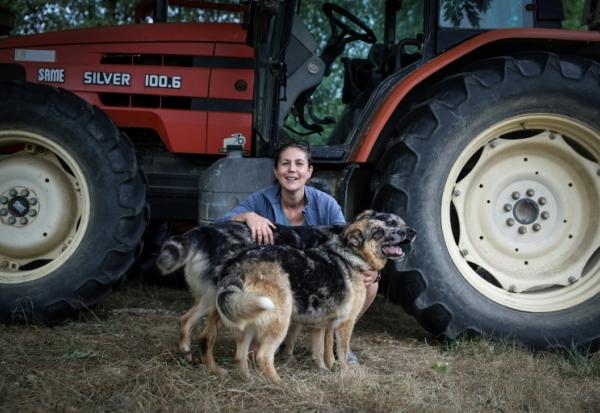 L'agricultrice Élodie Lac pose avec ses chiens dans sa ferme biologique à Cézac (Lot), le 19 août 2025