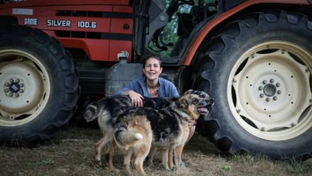 L'agricultrice Élodie Lac pose avec ses chiens dans sa ferme biologique à Cézac (Lot), le 19 août 2025