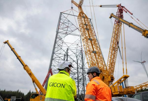 Jochen Grossmann, à gauche, PDG du groupe GICON, et le chef de projet Frank Adam, à sa droite, devant le chantier de la plus haute éolienne du monde à Schipkau, en Allemagne, le 13 mai 2026
