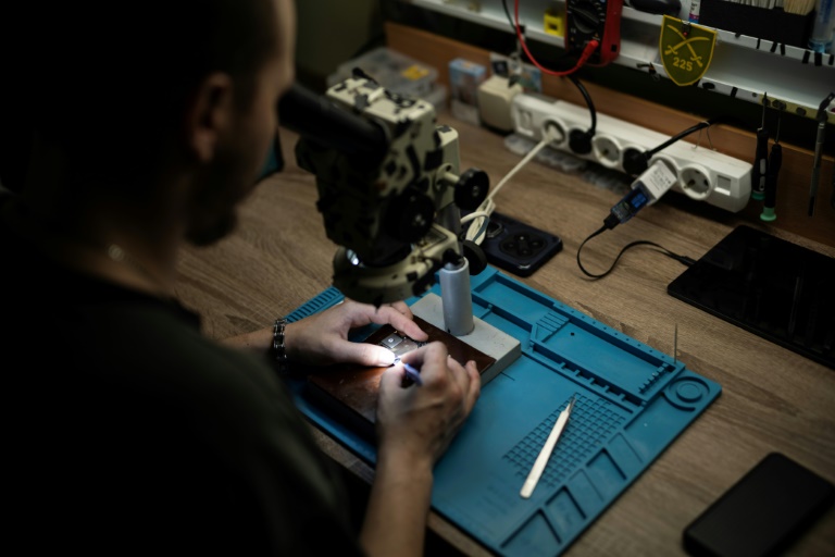 Un soldat ukrainien du bataillon de drones du 225e régiment d'assaut séparé soude un microprocesseur dans un atelier tenu secret, le 12 juin 2025
