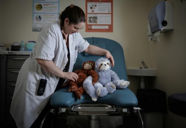 Céline Cazaux, infirmière, dispose des peluches sur une table d'examens gynécologiques de l'unité d'accueil pour enfants en Danger (Uaped) installée dans le centre hospitalier sud francilien (CHSF) à Corbeil-Essonnes, près de Paris, le 30 juin 2026