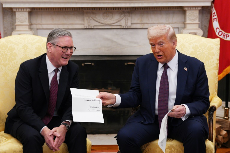 Donald Trump tient une lettre du roi Charles III, remise par le Premier ministre britannique Keir Starmer, le 27 février 2025 à la Maison Blanche, à Washington