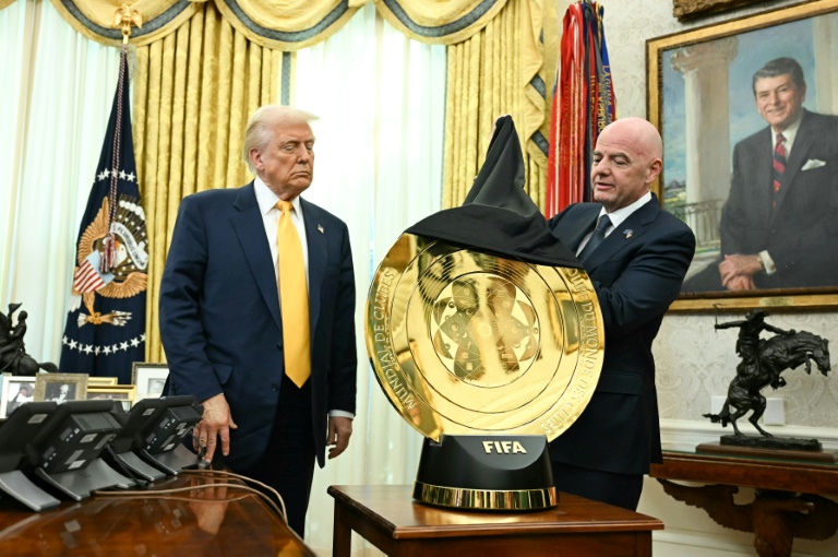 Le patron de la Fédération internationale de football, Gianni Infantino (d), dévoile le trophée de la Coupe du monde des clubs devant le président américain Donald Trump, à la Maison Blanche, le 7 mars 2025 à Washington
