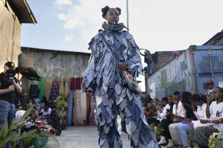 Une mannequin présente une création du styliste Morgan Azedy lors d'un défilé de mode organisé par des créateurs locaux spécialisés dans le recyclage de tissus et de vêtements usagés récupérés sur des marchés d'occasion et des décharges, le 10 octobre 2025 à Nairobi, au Kenya