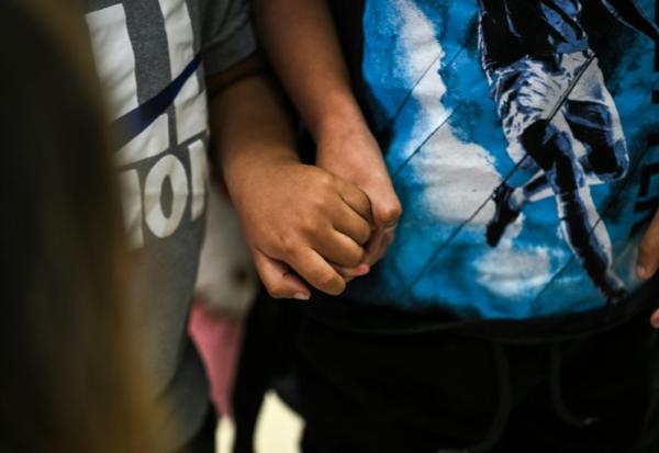 Deux enfants américains se tiennent le main à l'aéroport international de Miami avant de se rendre au Guatemala, le 4 décembre 2025 