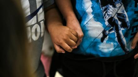 Deux enfants américains se tiennent le main à l'aéroport international de Miami avant de se rendre au Guatemala, le 4 décembre 2025 