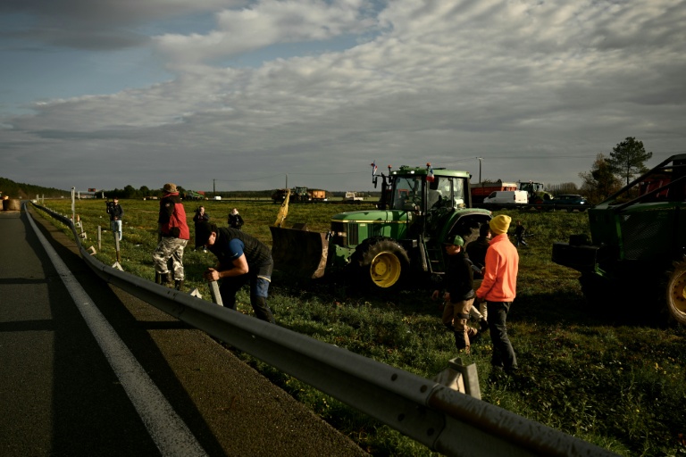 Des agriculteurs français démontent des barrières métalliques le long de l'autoroute A63 bloquée au niveau de l'échangeur de Cestas, en Gironde, le 16 décembre 2020