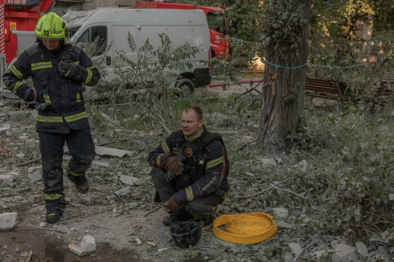 Des secouristes se reposent sur le site d'un immeuble résidentiel endommagé à la suite d'une frappe aérienne russe sur Kiev, le 2 juillet 2026