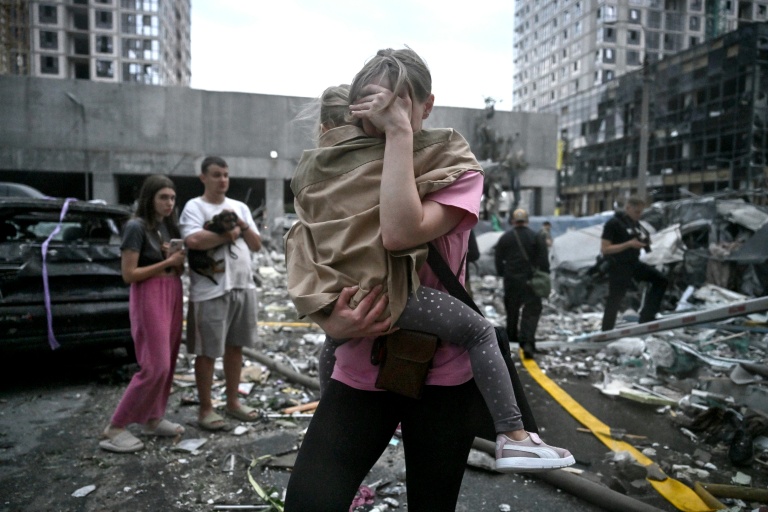 Une habitante tient sa fille dans ses bras après une frappe de missiles russes à Kiev, le 6 juillet 2026 en Ukraine