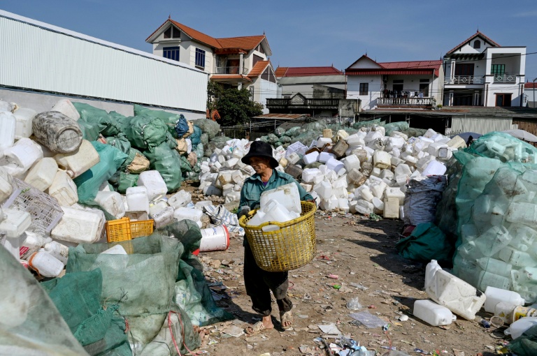 Un homme travaillent dans une décharge de déchets plastiques dans un village situé à la périphérie de Hanoï, le 25 novembre 2025