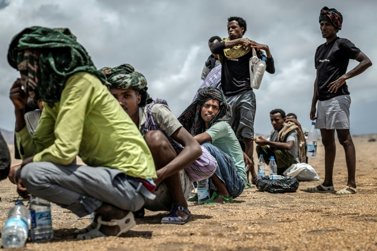 Des migrants éthiopiens se reposent, le 12 avril 2026, dans une zone désertique de Djibouti après avoir reçu de l'aide de la part de l'Organisation internationale pour les Migrations (OIM)