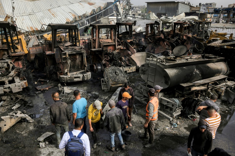 Des Palestiniens inspectent des engins de chantier et d'autres véhicules détruits dans le garage de la municipalité de Jabalia, touché par des bombardements israéliens, dans le nord de la bande de Gaza, le 22 avril 2025