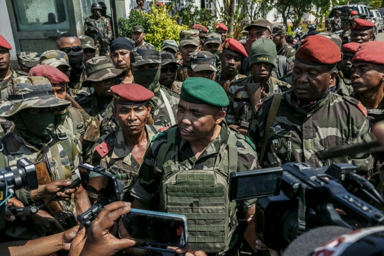 Des membres d'une unité de l'armée malgache parlent à la presse près de leur camp situé près d'Antananarivo, le 11 octobre 2025