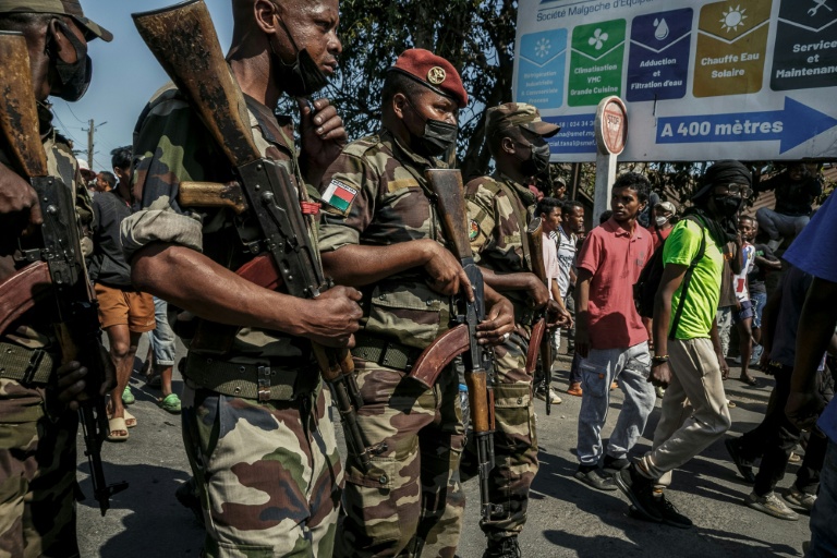 Des membres d'une unité de l'armée malgache se tiennent dans la rue près de leur camp situé près d'Antananarivo, le 11 octobre 2025
