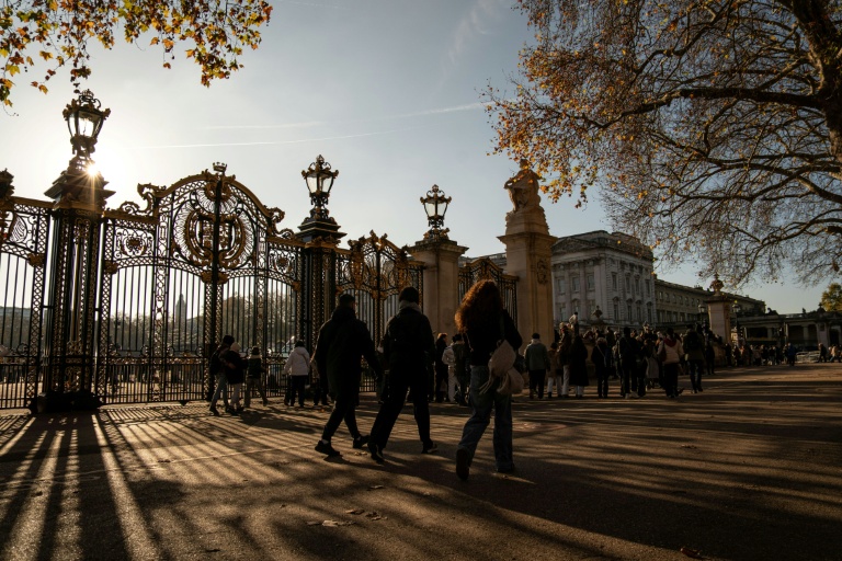 Des passants devant l'entrée du palais de Buckingham à Londres, le 21 novembre 2025