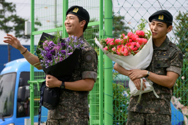 Les membres du boys band K-pop BTS, RM (L) et V à Chuncheon, en Corée du Sud, le 10 juin 2025, après leur libération du service militaire
