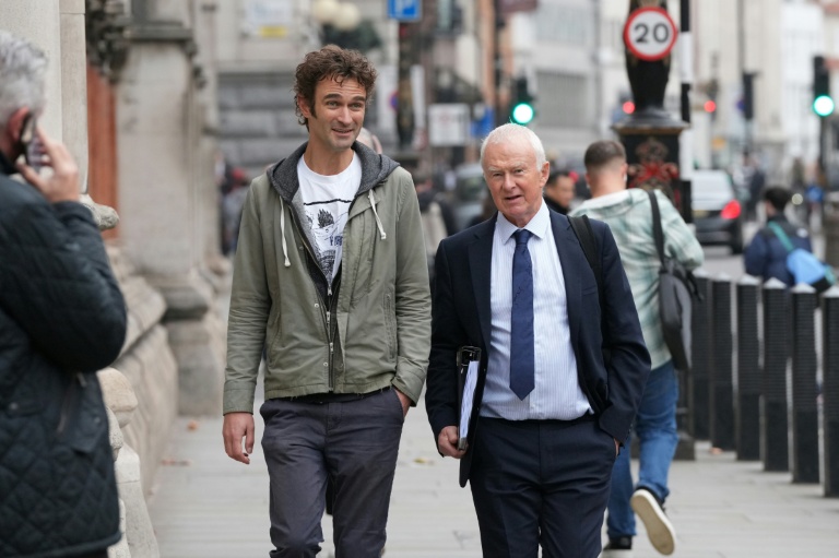 Adam Kamenetzky (g), l'un des plaignants, et l'avocat Martyn Day du cabinet Leigh Day, principal représentant des plaignants, arrivent à la Haute Cour à Londres, pour l'ouverture du procès de cinq géants de l'automobile impliqués dans le scandale des voitures diesel truquées, le 13 octobre 2025