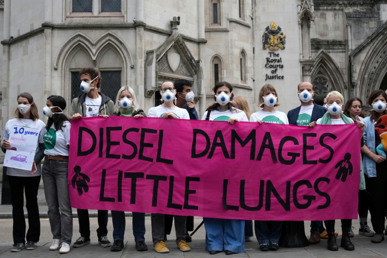 Des manifestants rassemblés devant la Haute Cour à Londres, à l'ouverture du procès de cinq géants de l'automobile impliqués dans le scandale des voitures diesel truquées, le 13 octobre 2025