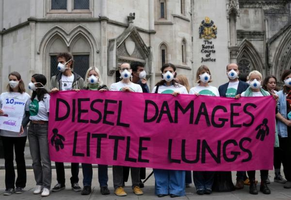 Des manifestants rassemblés devant la Haute Cour à Londres, à l'ouverture du procès de cinq géants de l'automobile impliqués dans le scandale des voitures diesel truquées, le 13 octobre 2025