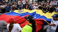 Des manifestants brandissent un drapeau vénézuélien géant lors d'un rassemblement en soutien au président vénézuélien déchu Nicolas Maduro à Caracas, le 10 janvier 2026