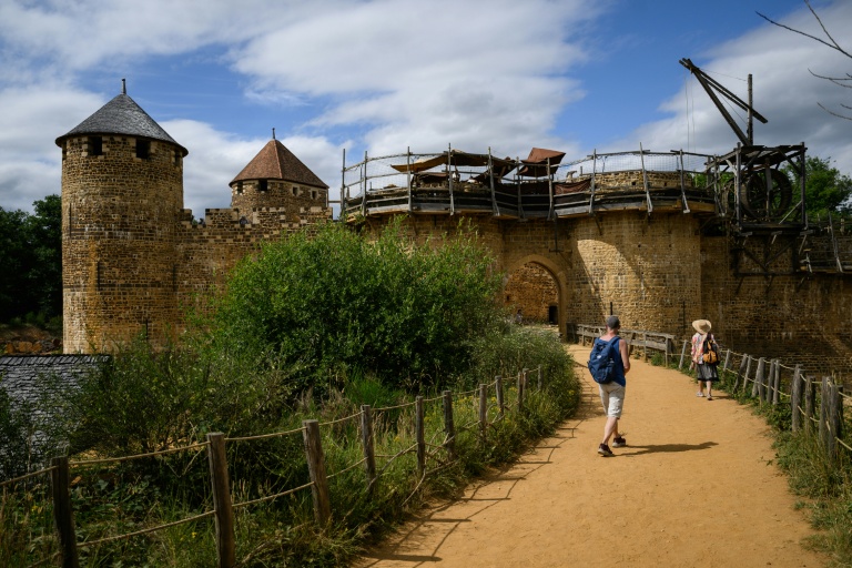 Des visiteurs parcourent le chantier du château de Guédelon, un château médiéval construit selon les méthodes du XIIIe siècle, à Trège, le 23 juin 2025 dans l'Yonne